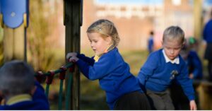 This image shows primary school pupils playing on a rope bridge playground equipment